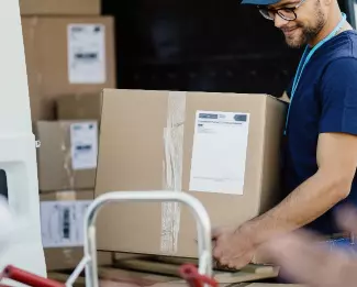 Worker unloading boxes from delivery van